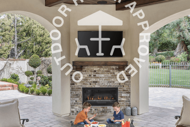 Outdoor Room Approved logo shown with children in front of a fireplace installed outdoors