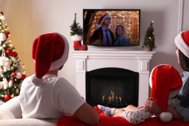 Family watching Christmas movies in front of a DelRay Square DRSQ42 fireplace